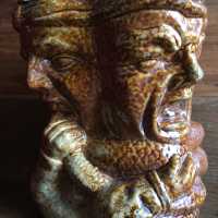 Anthropomorphous sanstone tobacco pot, with esoteric decor in round bump: 4 heads of men and a snake wrapped around their necks