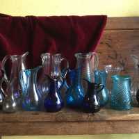 Translucent or colored, from an azure blue to a royal blue, light ocher or garnet going almost to black, these pitchers and decanters are typical of the glassworks of Normandy.