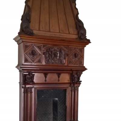 Richly carved fireplace in solid mahogany. The hood is decorated on both sides with dogs.