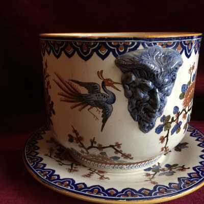 Polychrome decoration of stylized bouquets surrounded by fantastic birds. In half round-bump, on both sides, handle of grip, in blue color: a face of fauna.