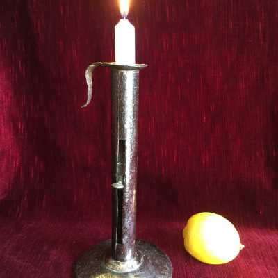 Candlestick in wrought iron sheet, "up and down" system, open cylindrical body of a "light" letting slide a thumb connected to the spring allowing a cup to mount the candle as it burns