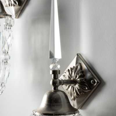 Detail of a "Libertine" wall light by Mark Brazier-Jones: cut glass arrow and diamond-shaped base with rosette